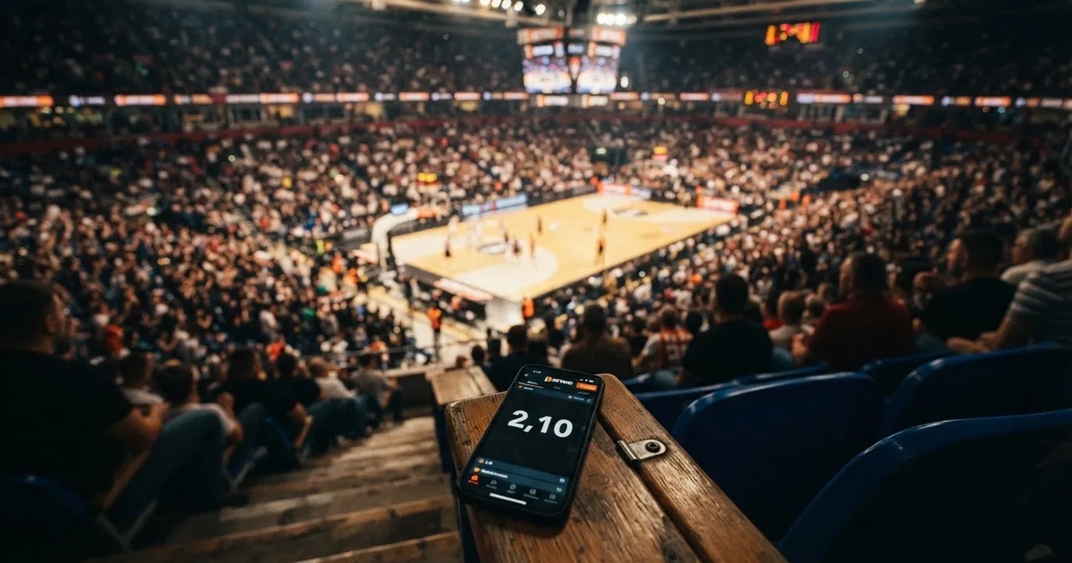 Een volle sporthal onder schijnwerpers, van grote afstand gefotografeerd