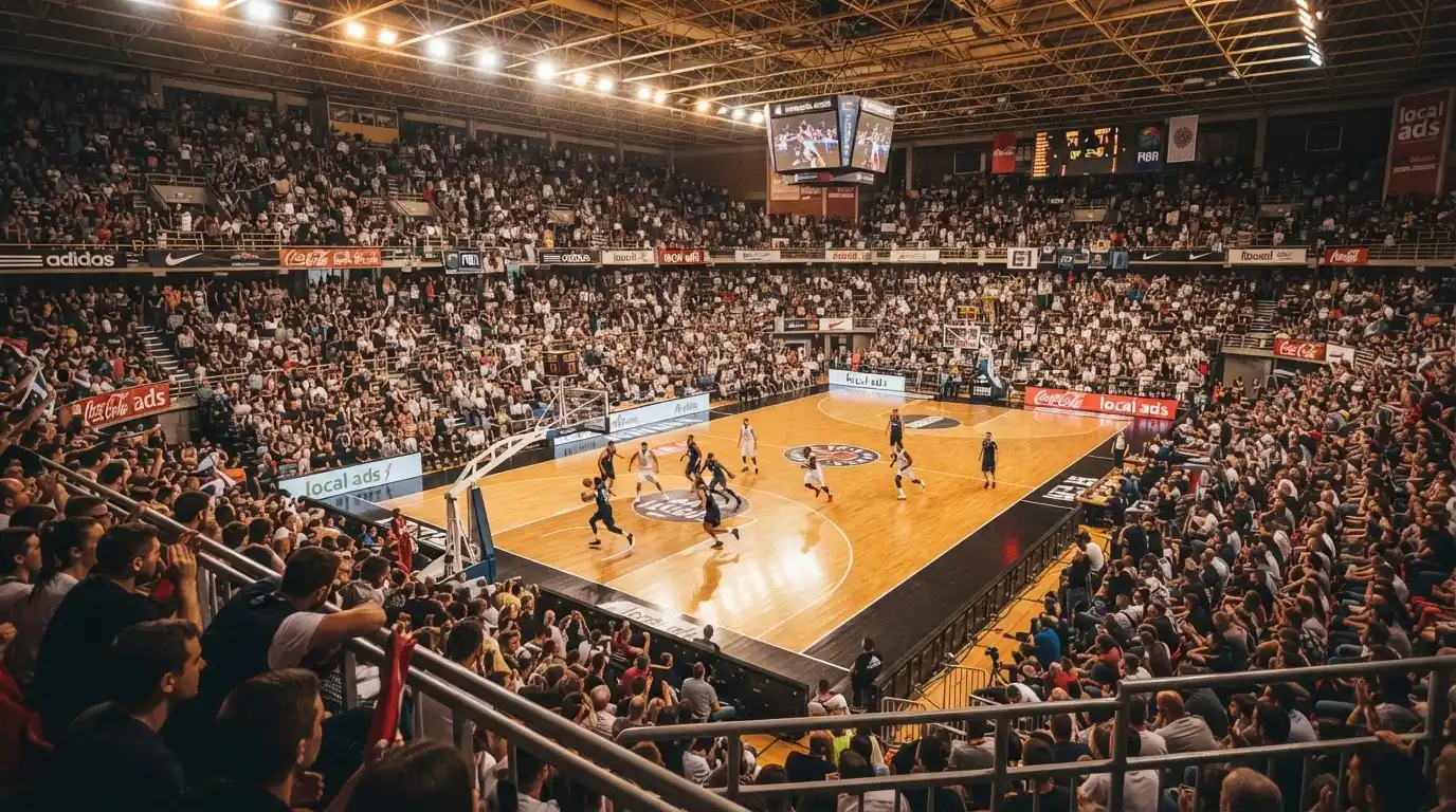 Een volle sporthal onder schijnwerpers, van grote afstand gefotografeerd